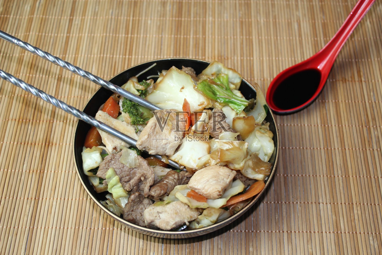 鸡肉和牛肉配蔬菜煮熟，并用酱油调味照片摄影图片