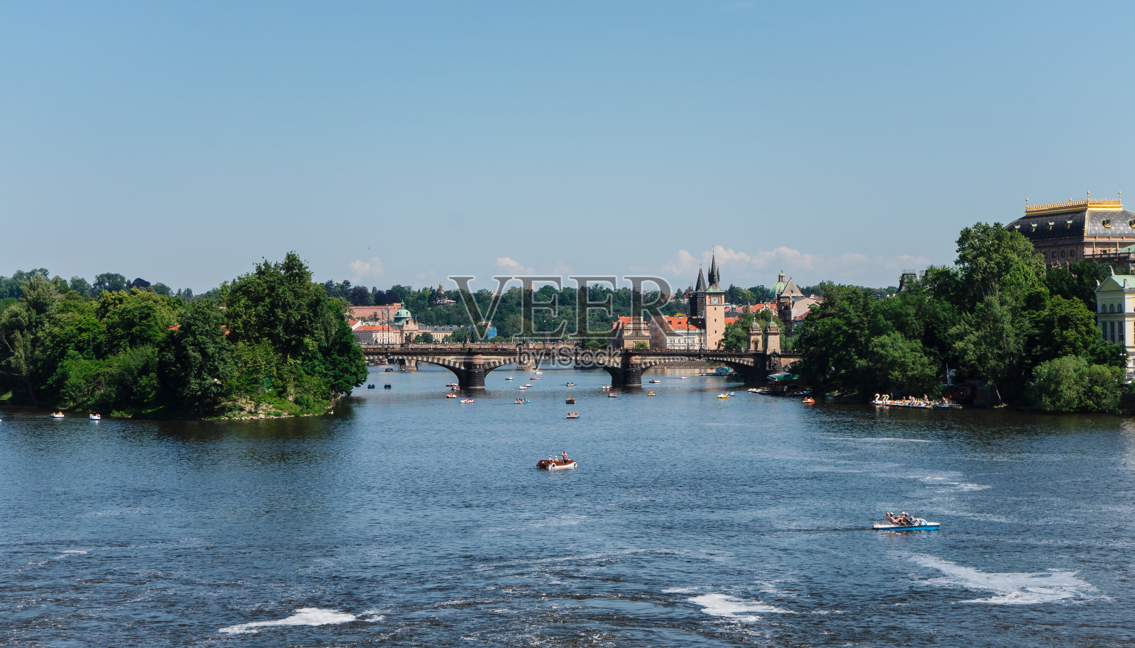 宽阔的河流和双体船在旅游城市的中心。双体船在古城里的伏尔塔瓦河上。照片摄影图片