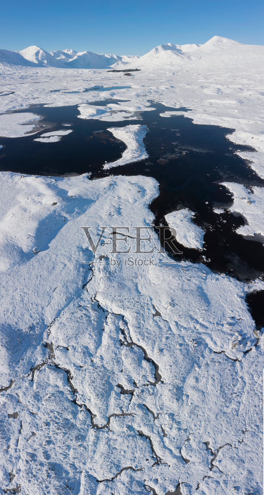 史诗般的无人机冬季景观图像的湖巴和白雪覆盖的山脉背景在苏格兰高地的蓝天冬天的一天照片摄影图片