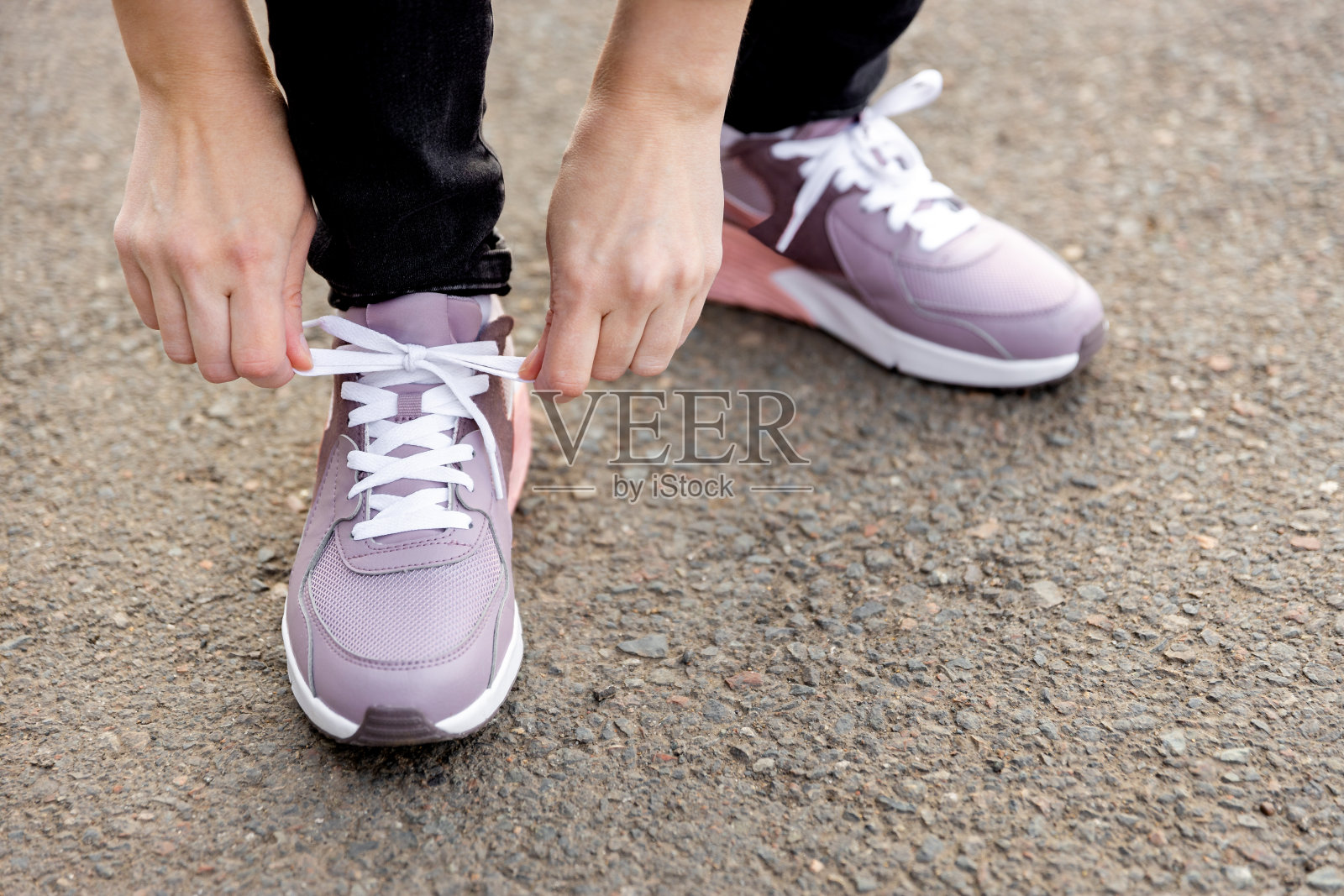 女人站在路上系鞋带照片摄影图片