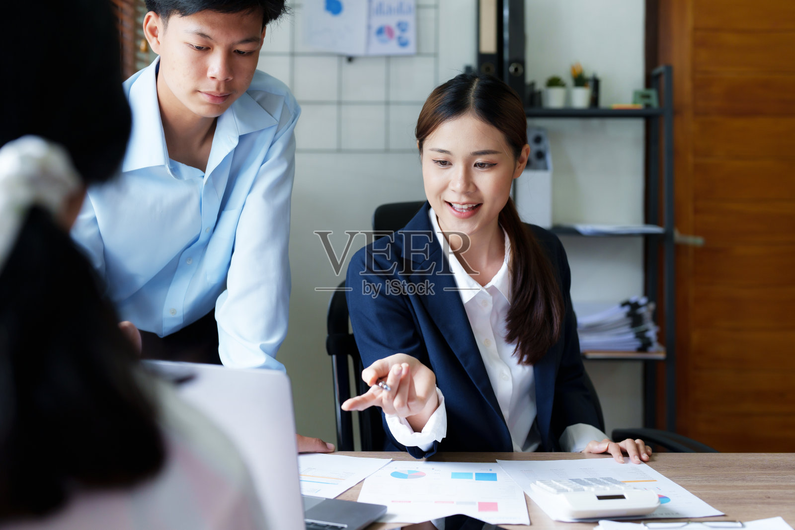 集团企业使用计算器、文件、计算机分析工作。照片摄影图片