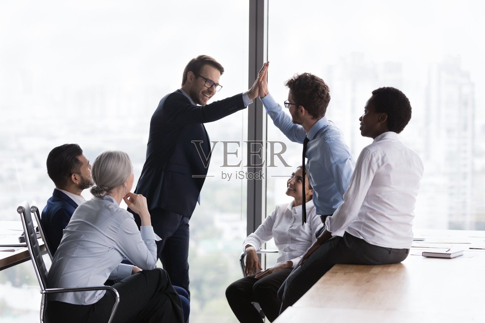 快乐的同事在团队会议上鼓掌，庆祝团队的成功照片摄影图片