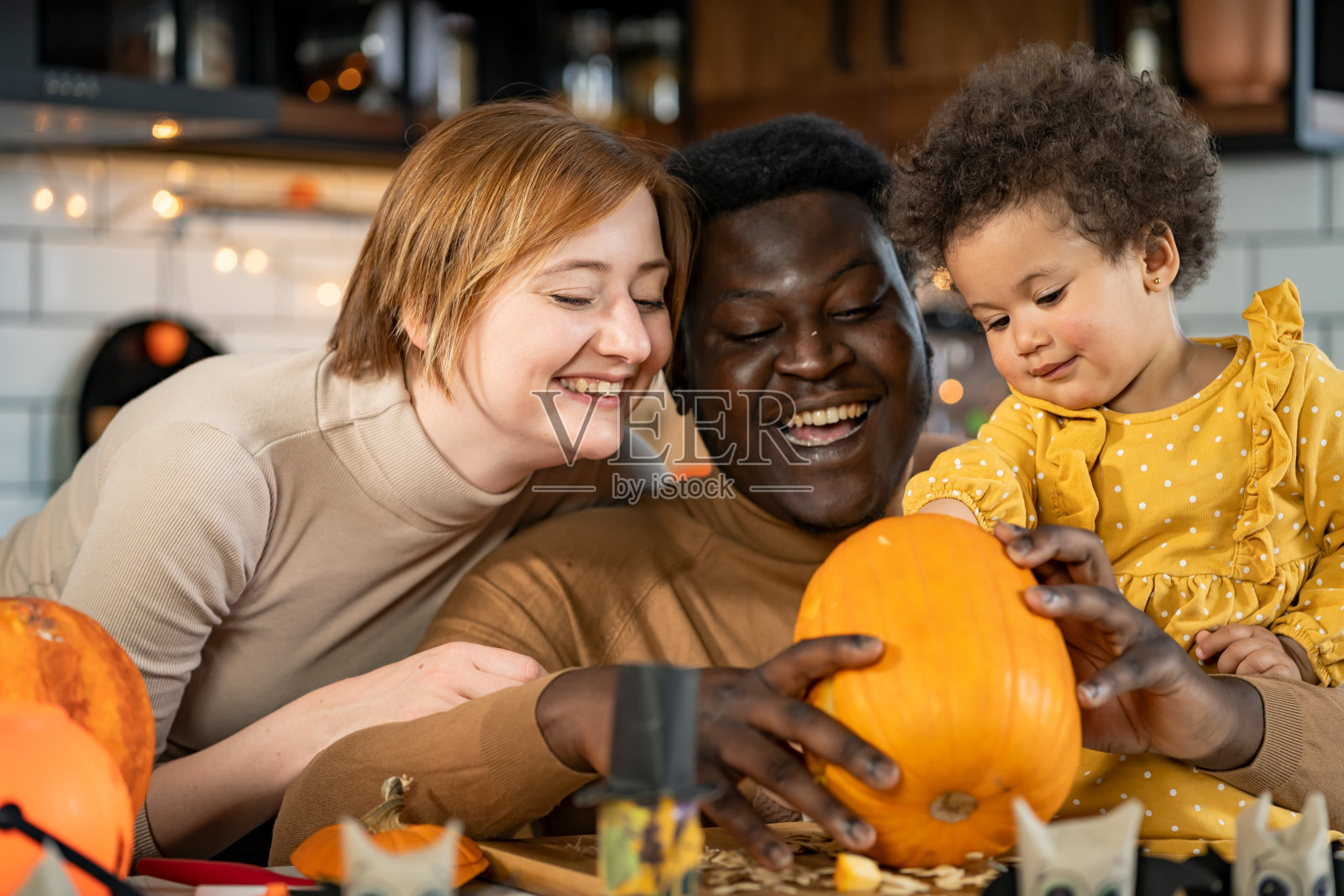 多民族家庭和小孩雕刻南瓜准备万圣节假期，制作杰克灯照片摄影图片