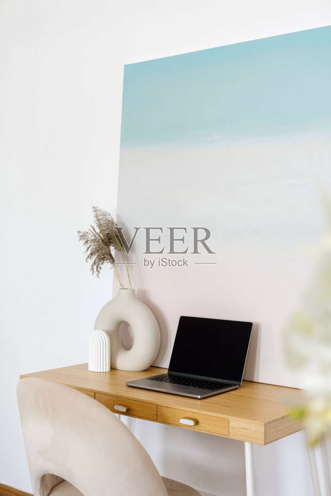 光线充足的房间，桌上有现代的笔记本电脑和抽象的艺术绘画照片摄影图片