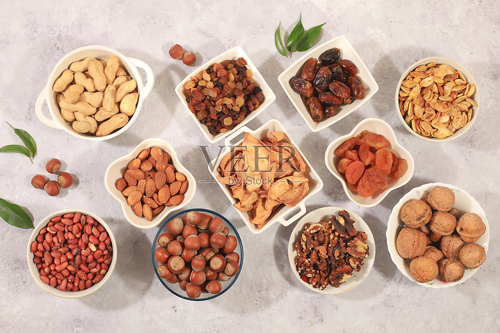 各种坚果和干果的组合，健康的天然食品概念，杏仁，坚果，山核桃，开心果，腰果，核桃和松子，苹果，葡萄干，杏干，照片摄影图片