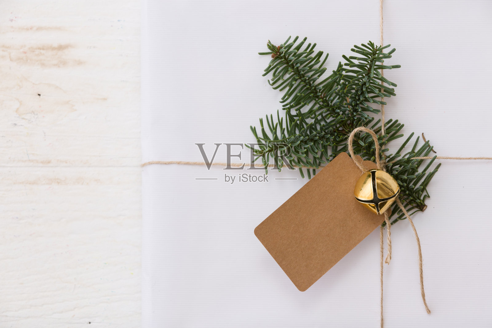 俯瞰白色圣诞礼物装饰圣诞树树枝，标签和铃铛。照片摄影图片