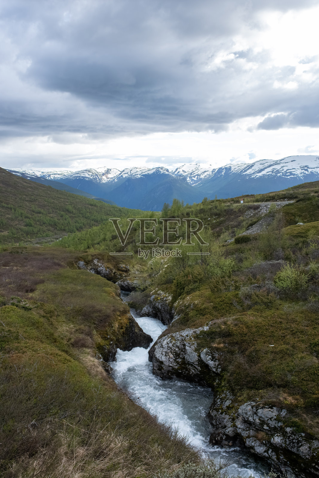 挪威美丽的风景。Vestland。奥兰斯旺根山脉的小溪和雪山的美丽景色。多云的一天。有选择性的重点照片摄影图片
