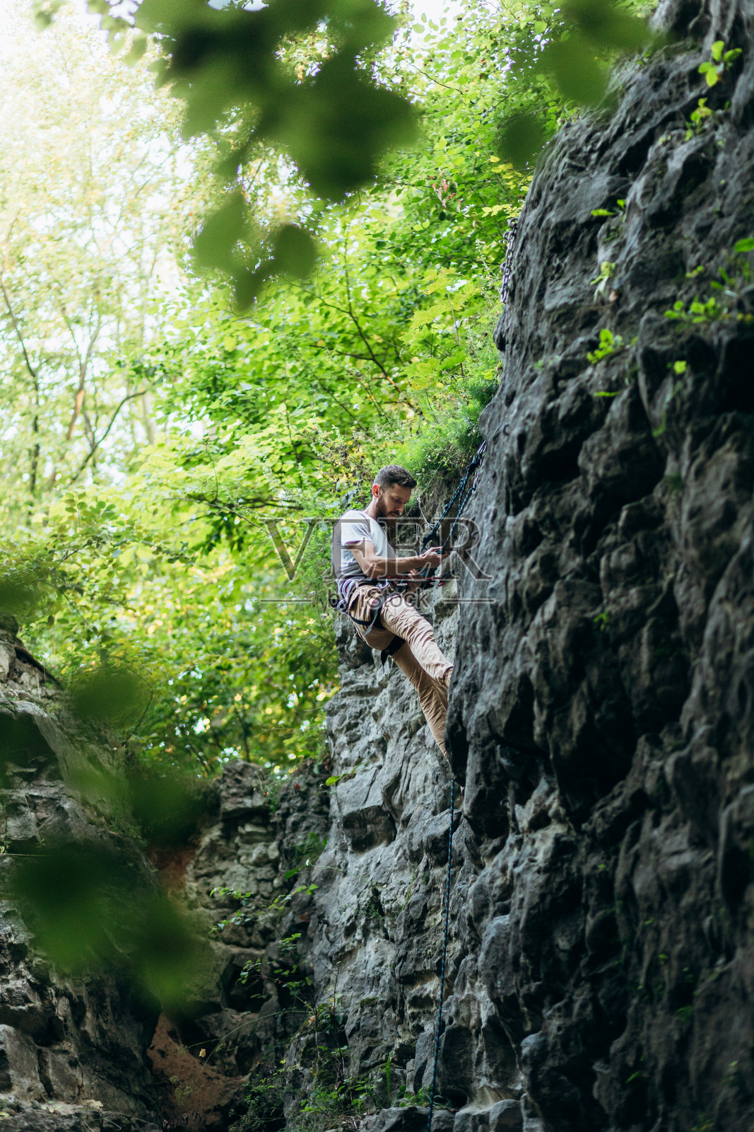 那个在岩石上爬的人照片摄影图片