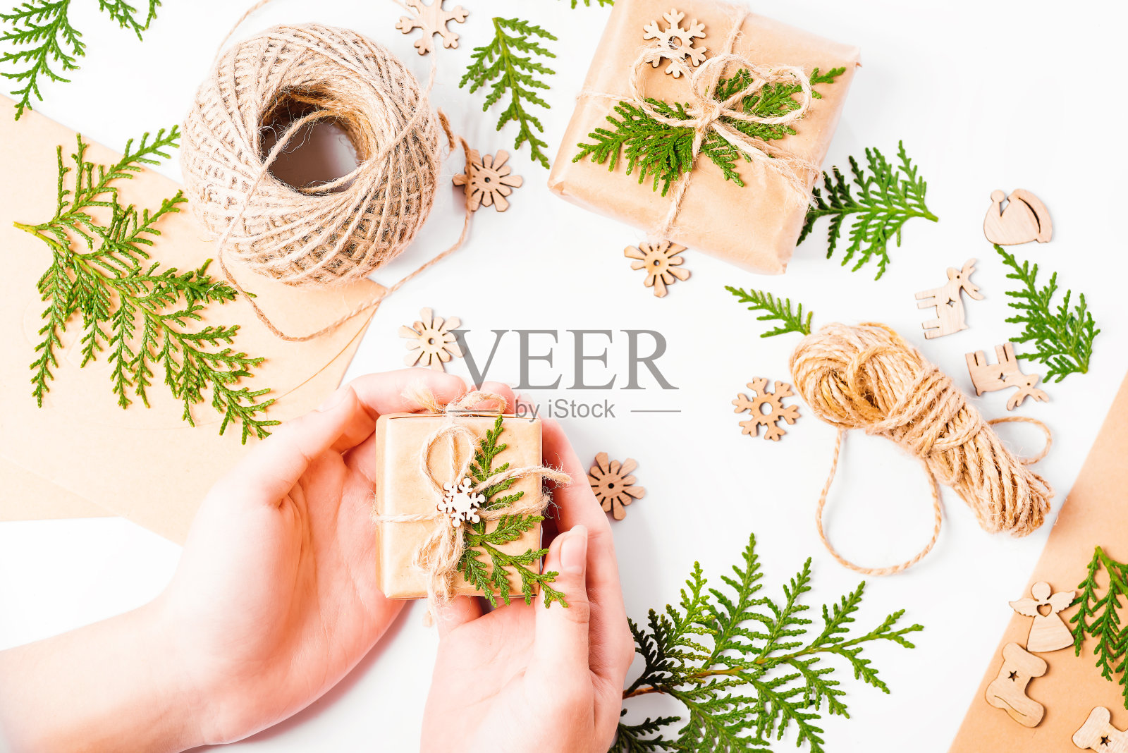圣诞家居装饰。新年贺卡背景。特写。圣诞节，寒假，新年的概念。女孩的双手在制作新年礼物的构图。新年礼物。照片摄影图片