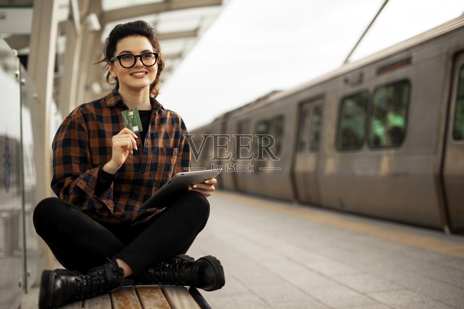 年轻女子在地铁网上购物。照片摄影图片