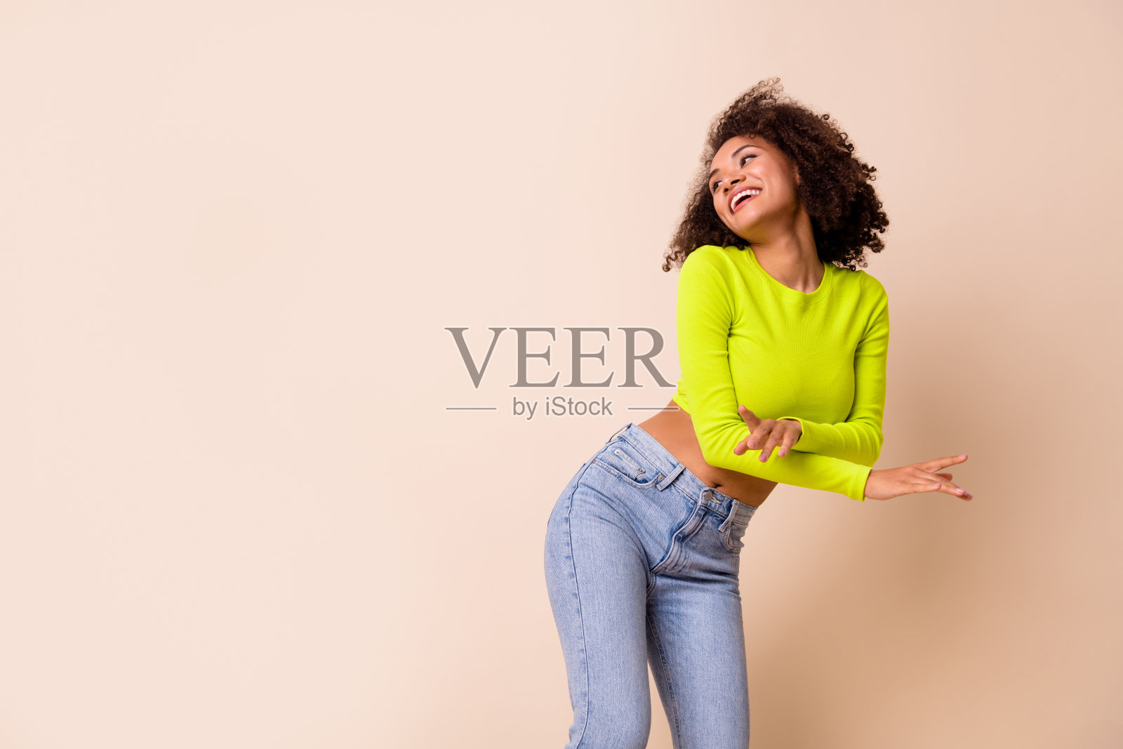 画像年轻微笑可爱的女士穿黄色上衣醉酒跳舞看空空间孤立在米色背景照片摄影图片