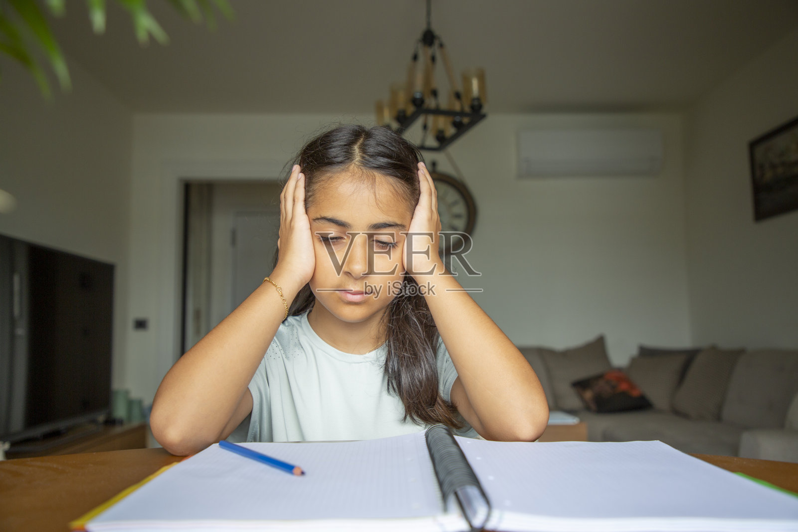 一个小女孩在家里的书桌上做作业照片摄影图片