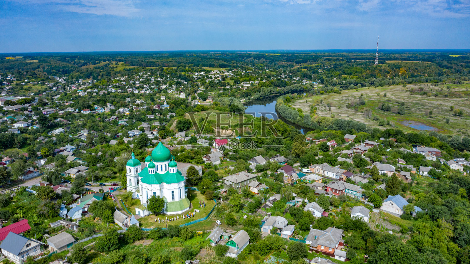 在一个美丽的夏日，鸟瞰村庄里的一座老教堂。白天从上方拍摄的一幅古代教堂的照片照片摄影图片