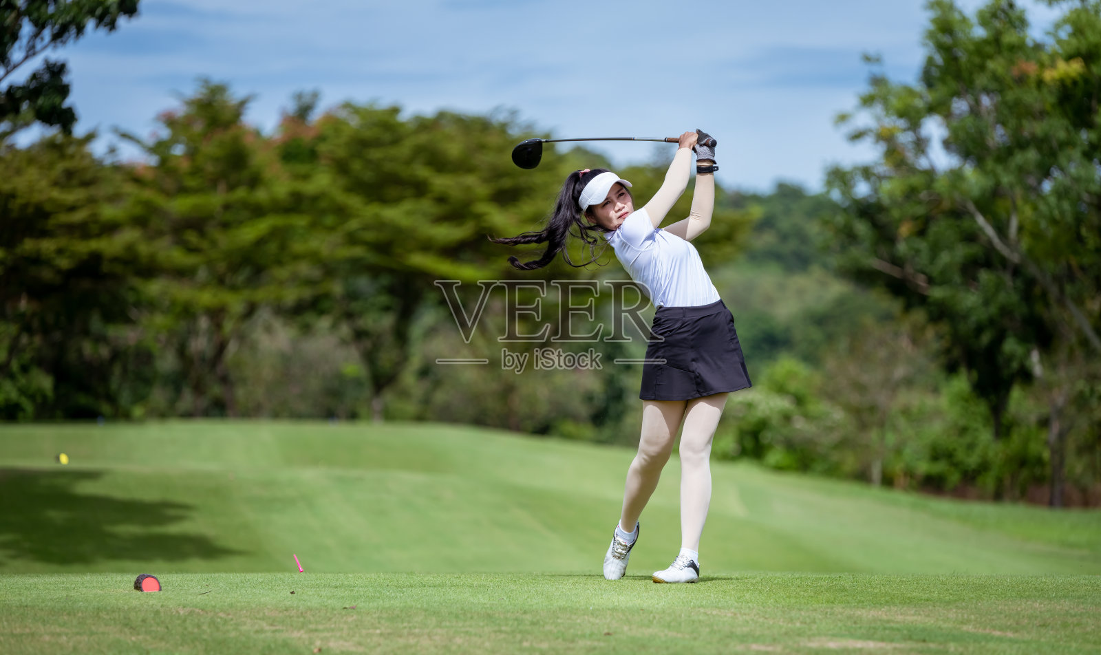 职业女子高尔夫球选手在高尔夫球场高尔夫球锦标赛比赛中为冠军而打高尔夫球。照片摄影图片