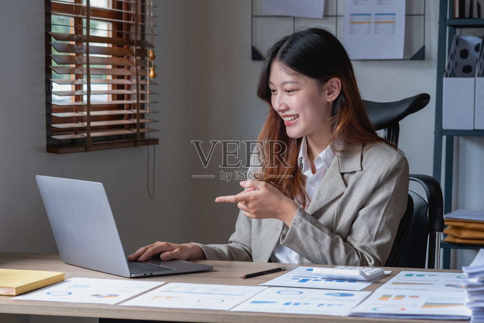 女商人通过笔记本电脑向她的主管展示利润数据和图表。照片摄影图片