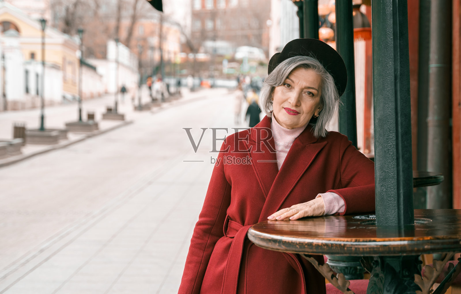 年长的妇女走在餐厅的咖啡桌上。退休的老妇人走在城市街道上。时尚优雅的老人退休人员。在大都市度过了平静快乐的岁月照片摄影图片