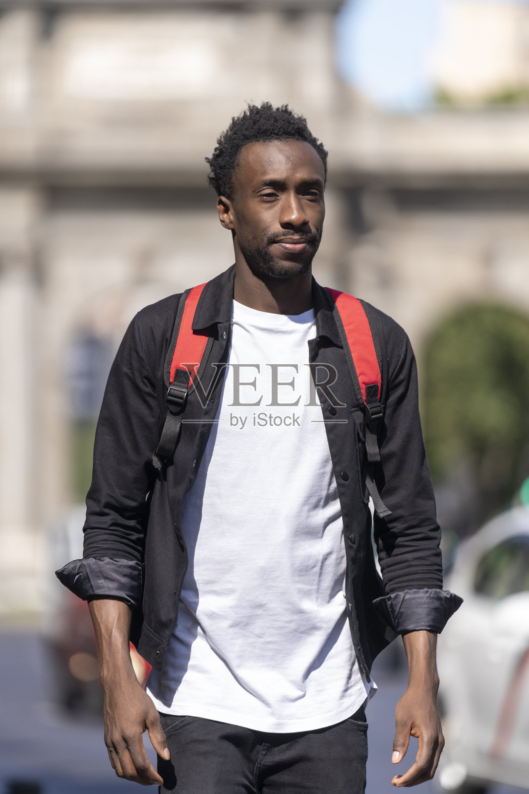 一个快乐的人背着红色背包走路的肖像照片摄影图片