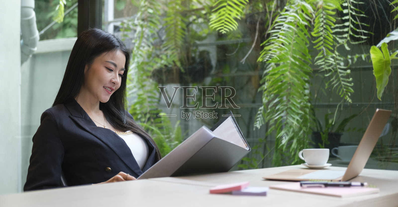 在办公室工作的专业女商人，分析市场研究报告和收入统计数据。照片摄影图片