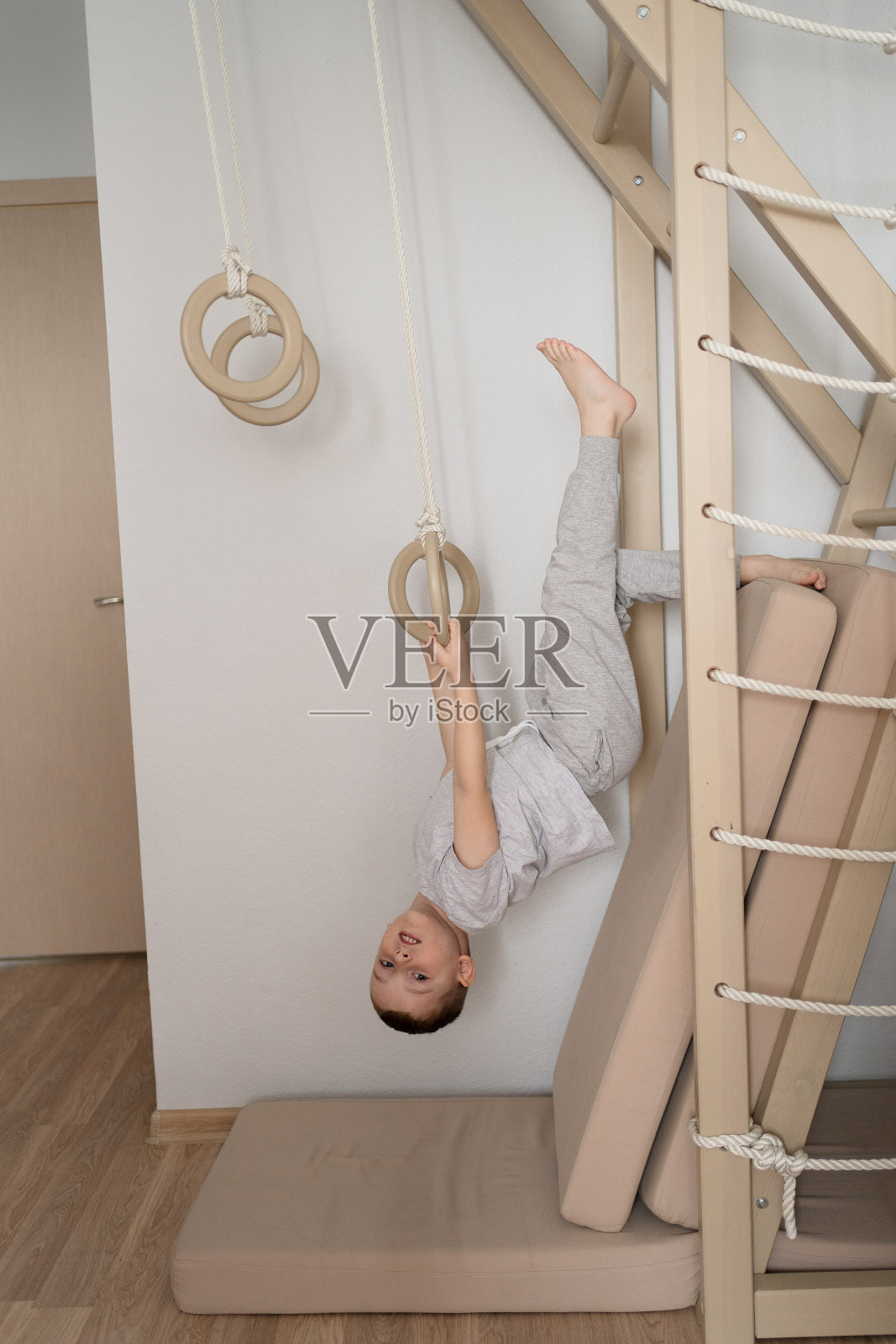 一个孩子在瑞典墙上玩体育，一个男孩爬梯子，运动的概念照片摄影图片