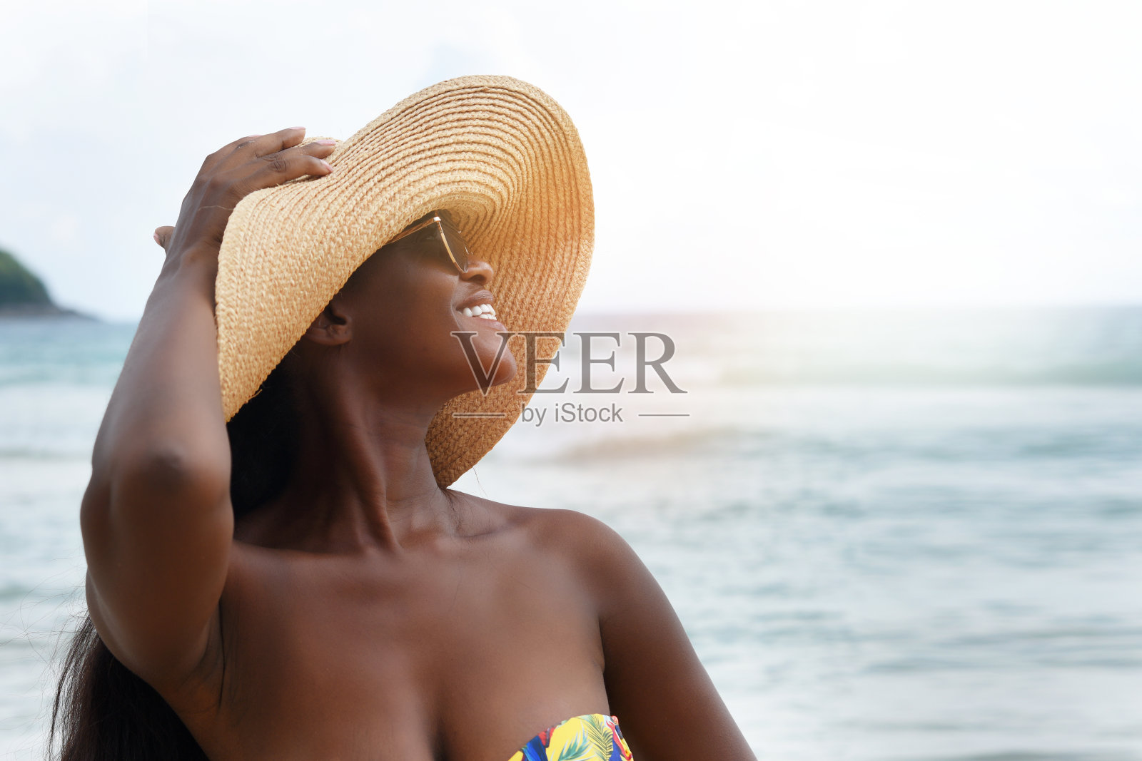 美丽的非洲女人穿着比基尼在海滩上享受暑假照片摄影图片