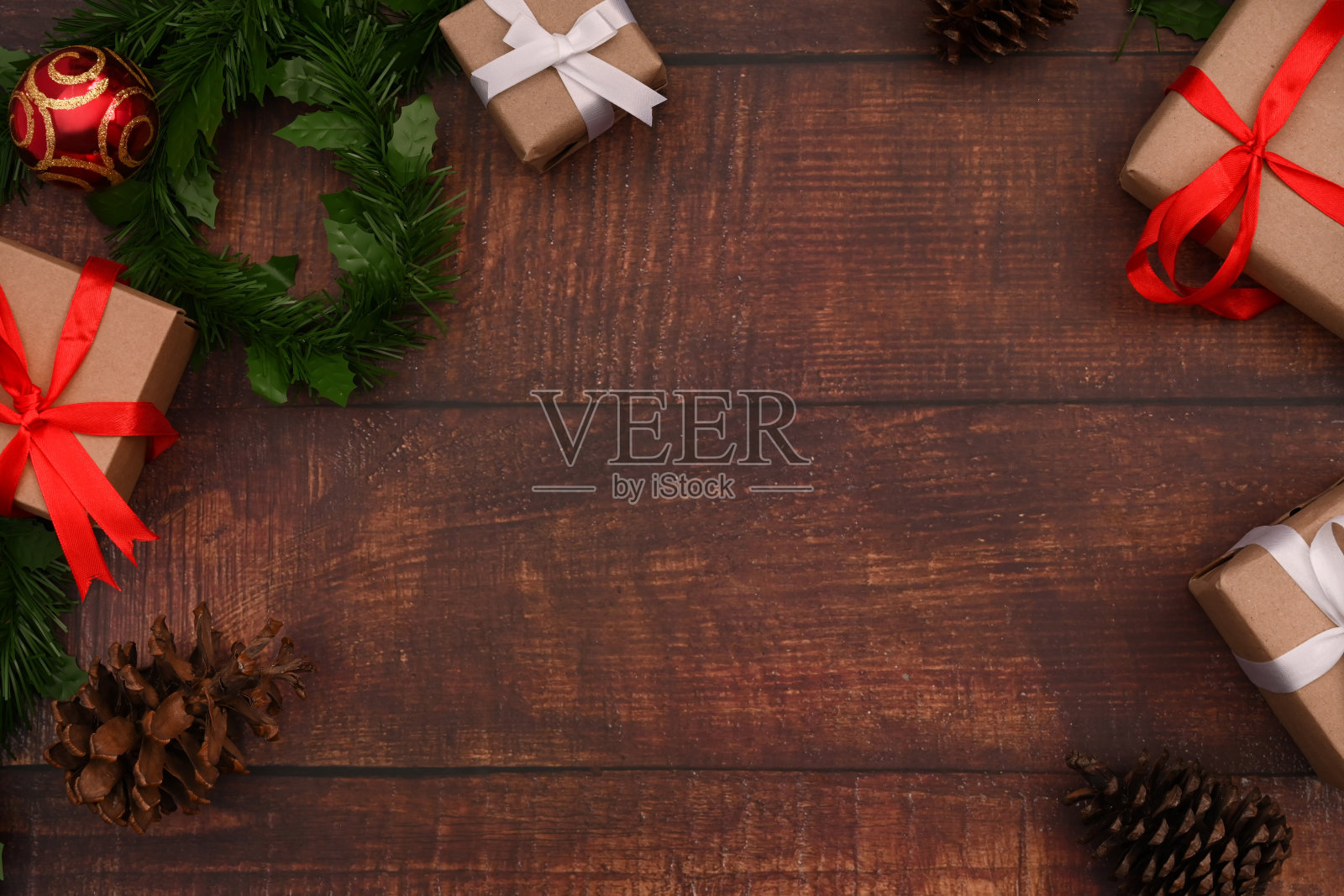 俯瞰圣诞礼盒，杉树树枝和松果在木制背景。圣诞背景的概念。照片摄影图片