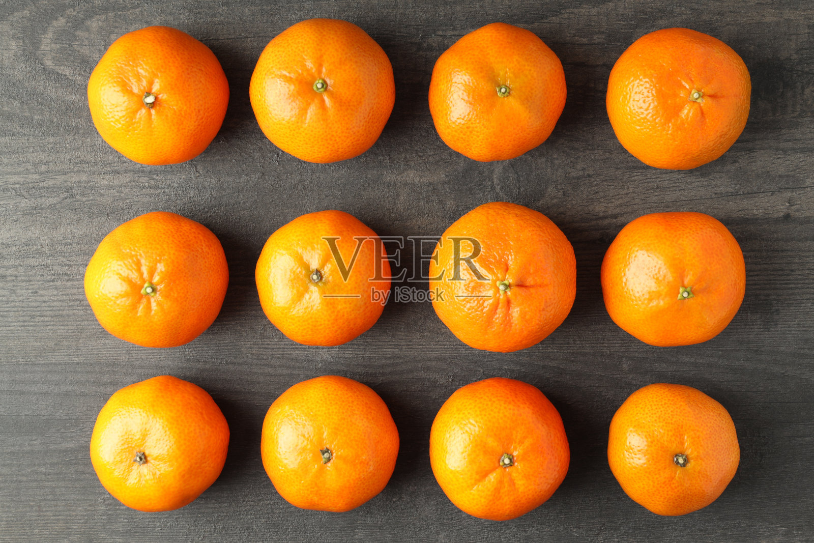 平躺在有质感的木桌上，放着美味的橘子照片摄影图片