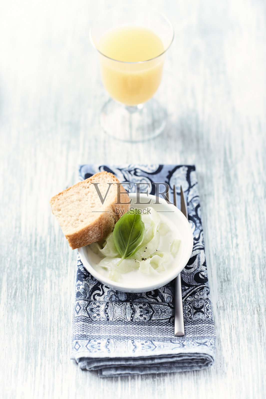 用黄瓜、酸酸奶和新鲜罗勒制作的酸奶酱。明亮的木制背景。照片摄影图片