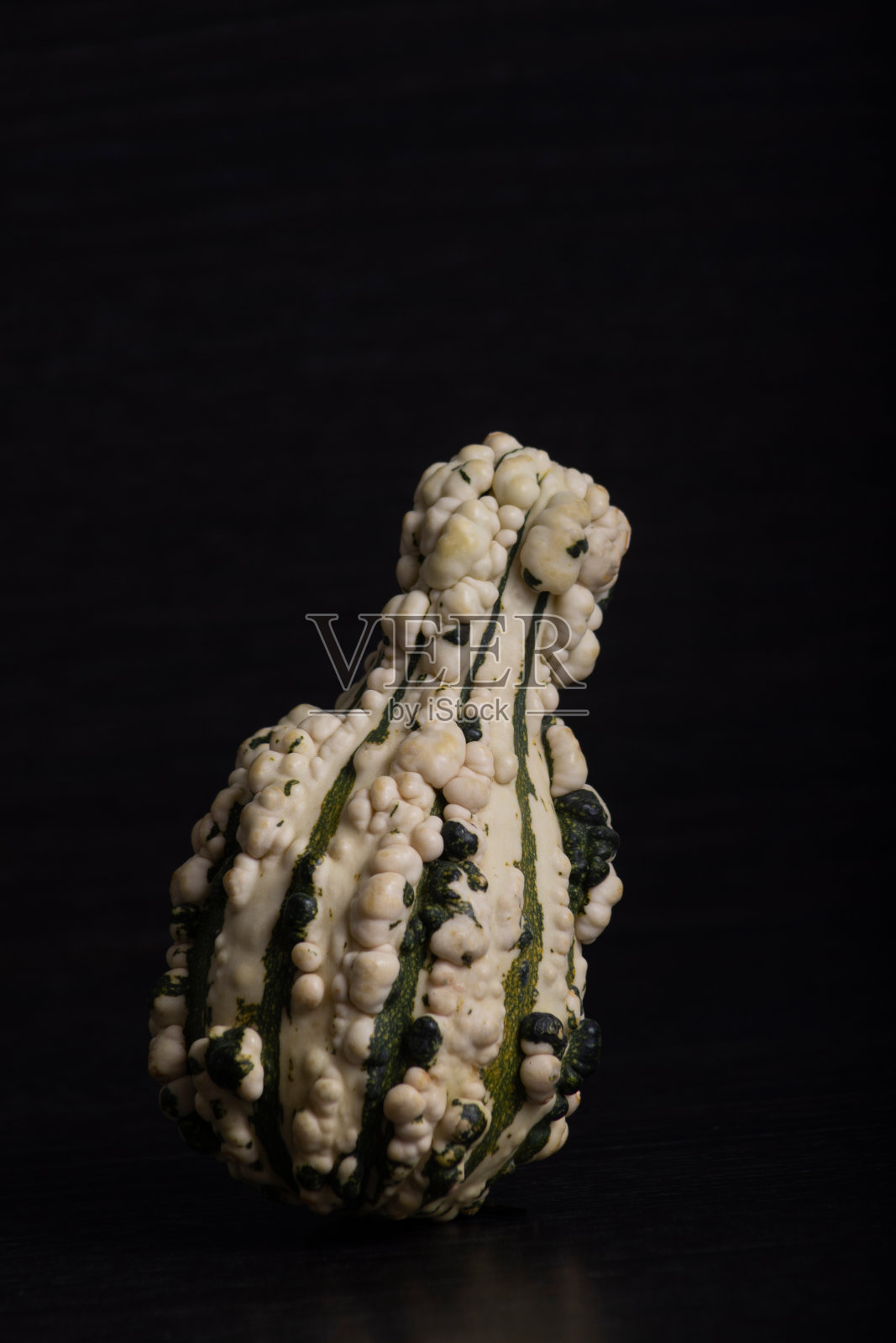 各种颜色和外形的迷你南瓜，黑色的背景和装饰照片摄影图片