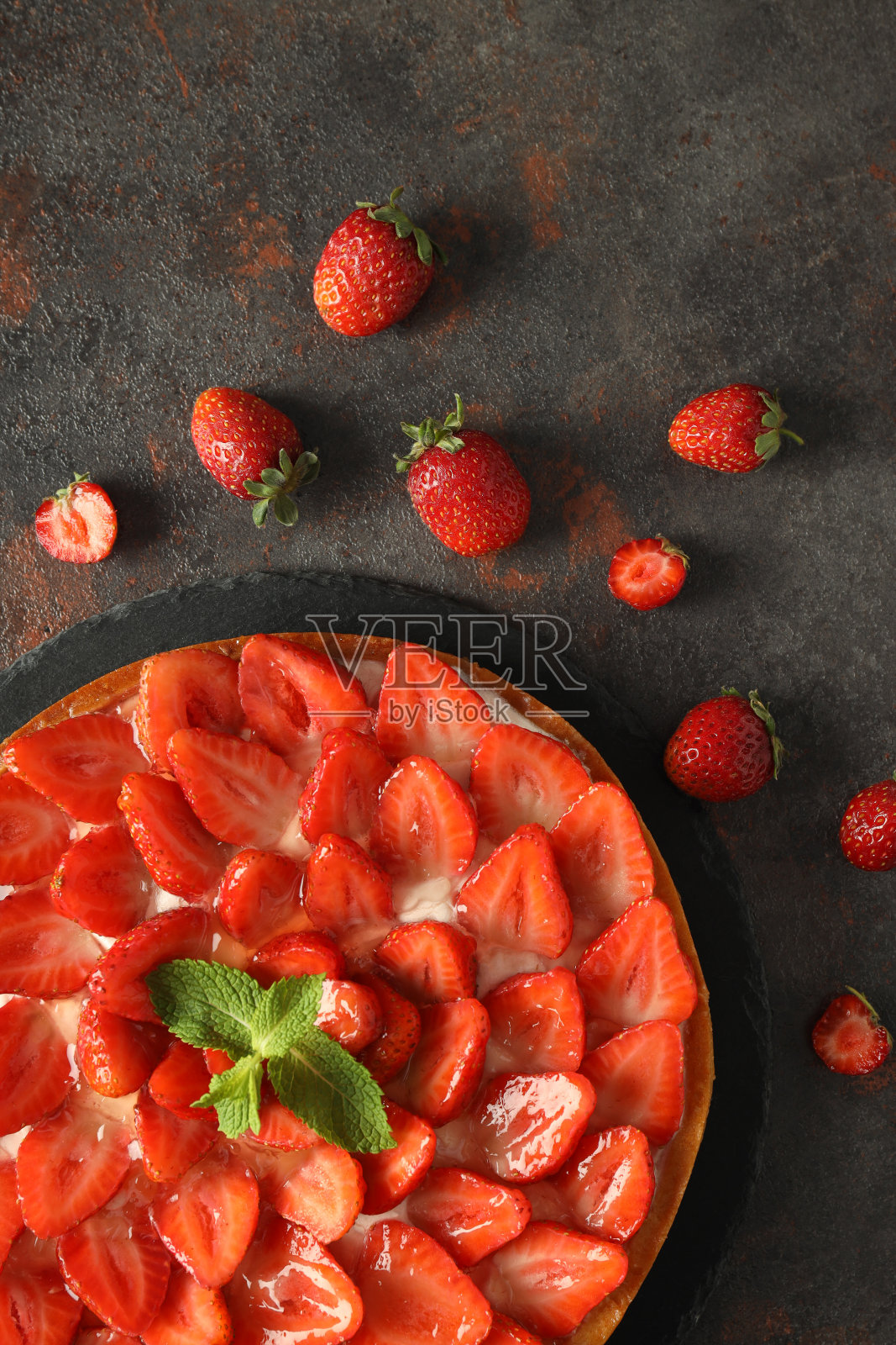托盘草莓挞在黑色质感的桌子上照片摄影图片