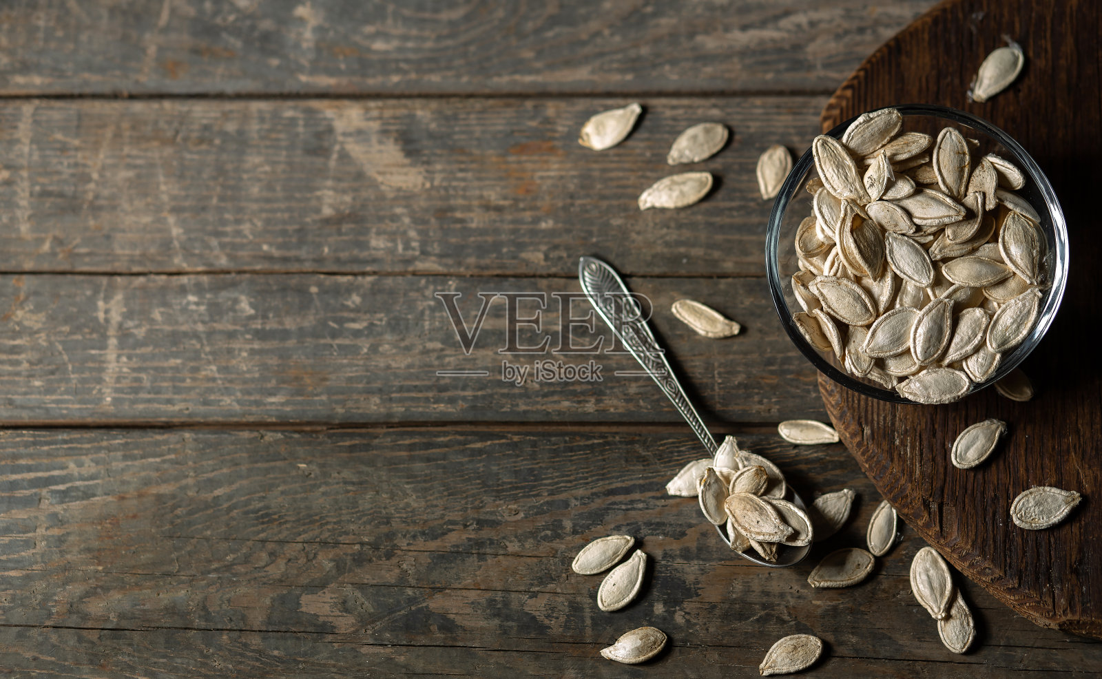 南瓜籽放在木制背景的棕色盘子里。照片摄影图片