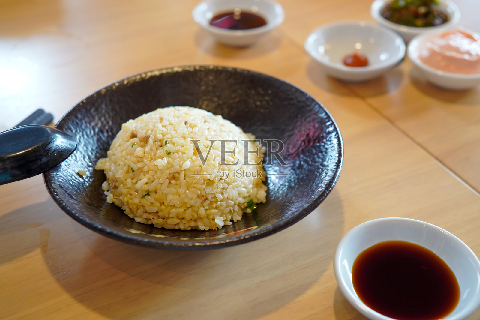 精选重点、Chahan(炒饭)、蒜香炒饭、日式炒饭。亚洲中国中国菜。鸡蛋和蔬菜炒饭在餐馆的黑色盘子照片摄影图片