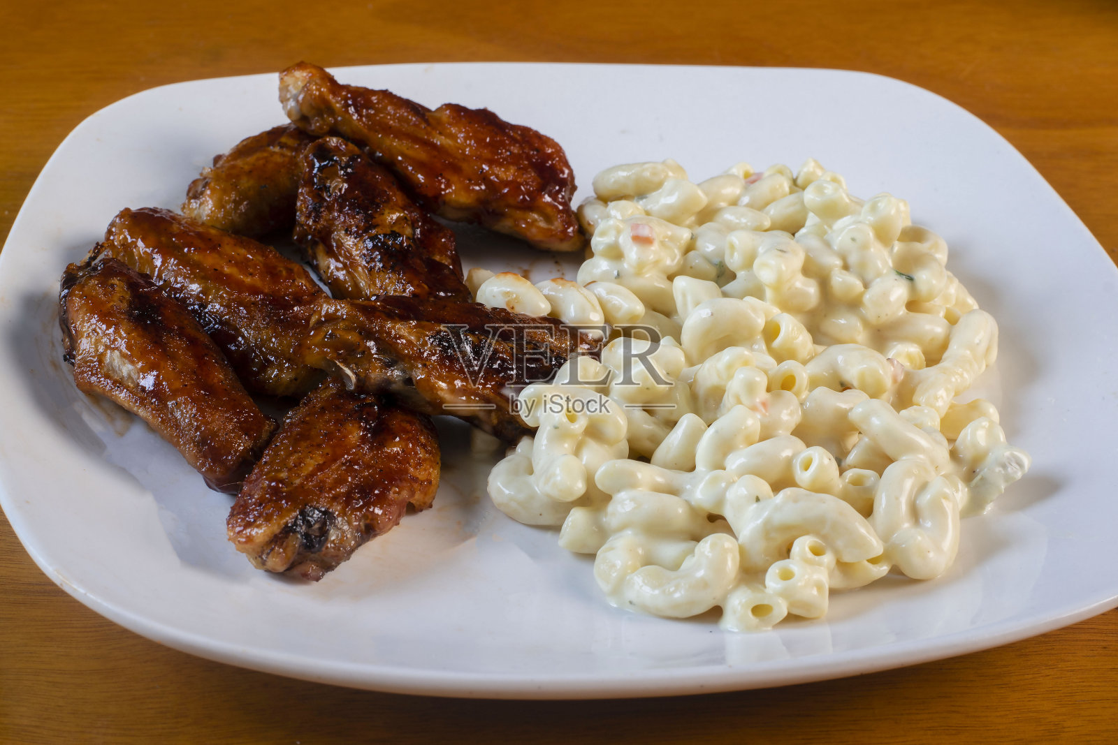 蜂蜜烧烤鸡翅配通心粉沙拉照片摄影图片