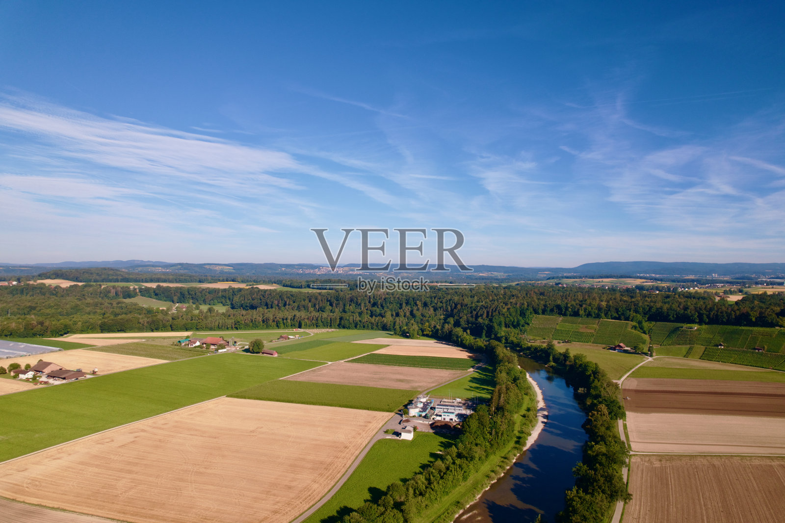 在一个阳光明媚的夏日早晨，在广东Zürich的Andelfingen村，图尔河的农田收获鸟瞰图。照片摄影图片