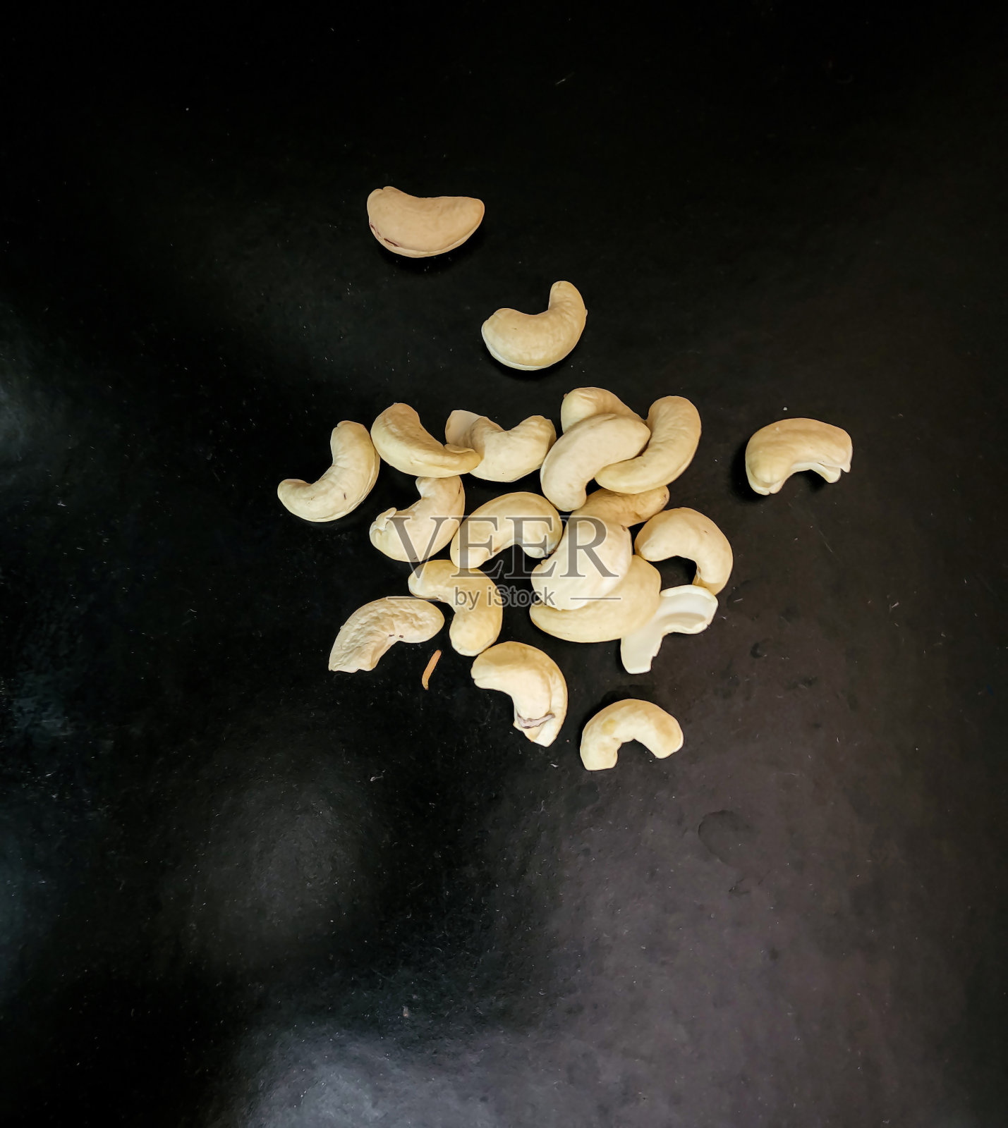 黑色背景的有机腰果，健康美味的干果。关注对象。食品摄影,广告。角度视图。照片摄影图片