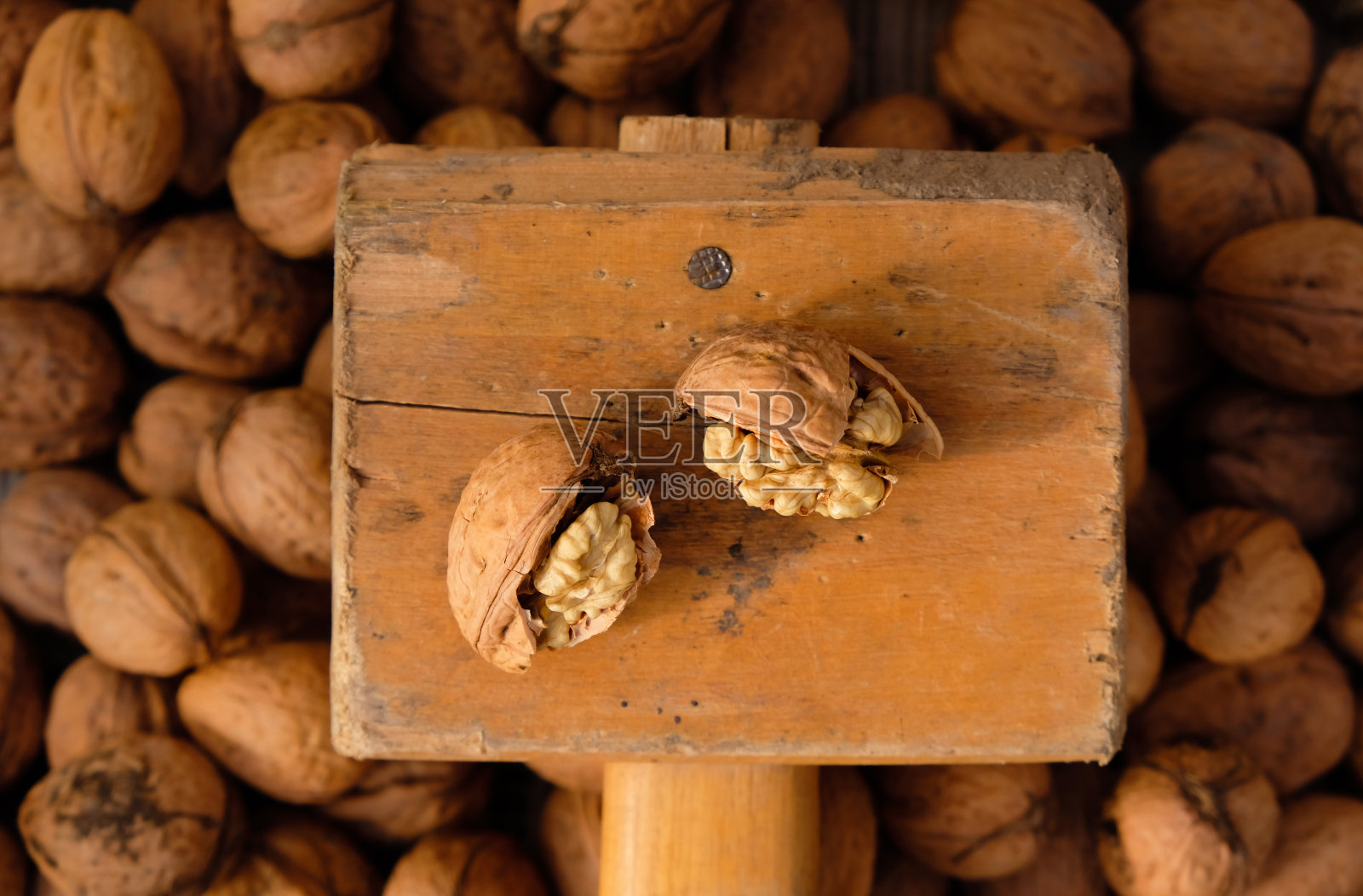 碎核桃和一把旧木锤。前视图。照片摄影图片