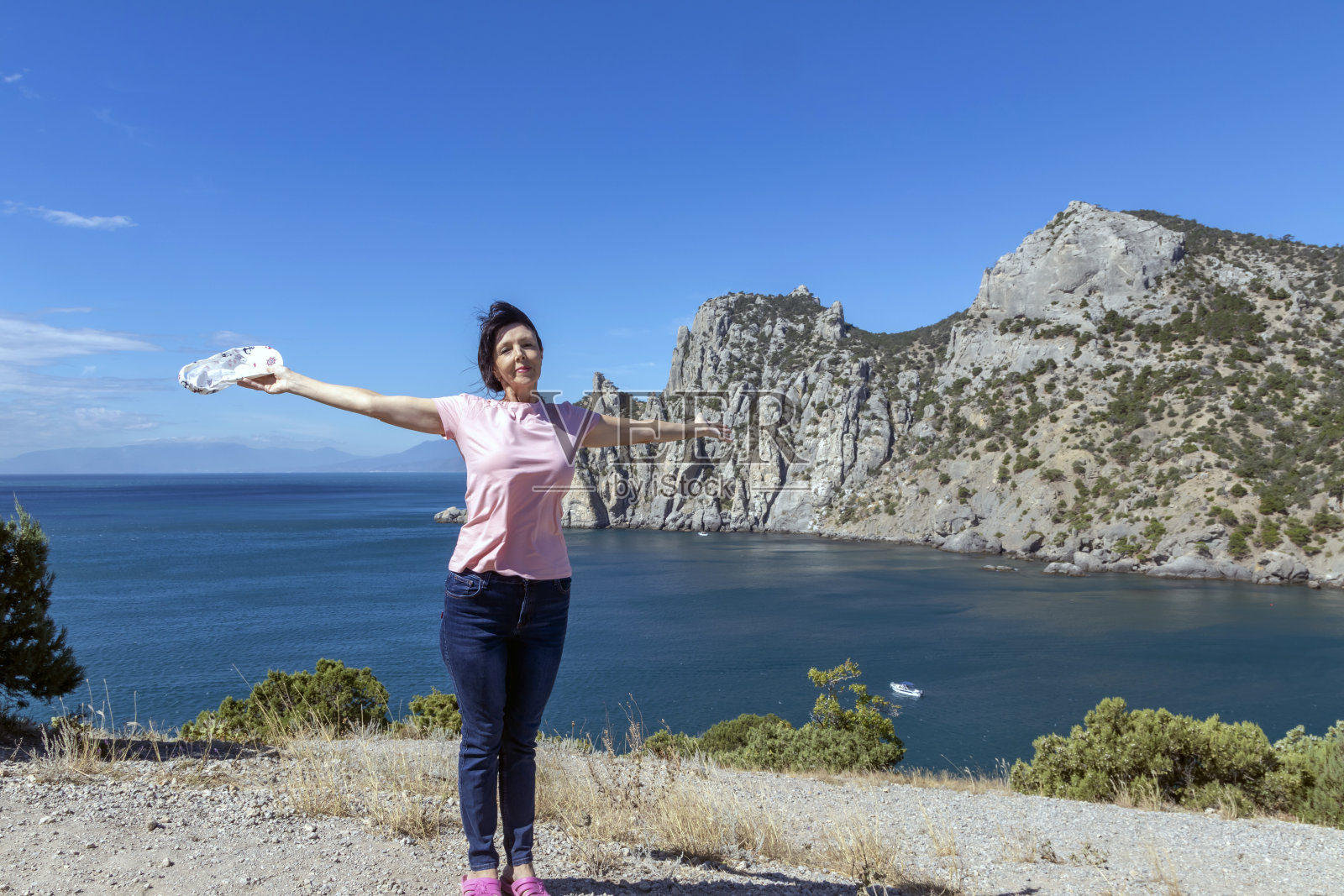 一名女子在海上的岩石上做瑜伽照片摄影图片