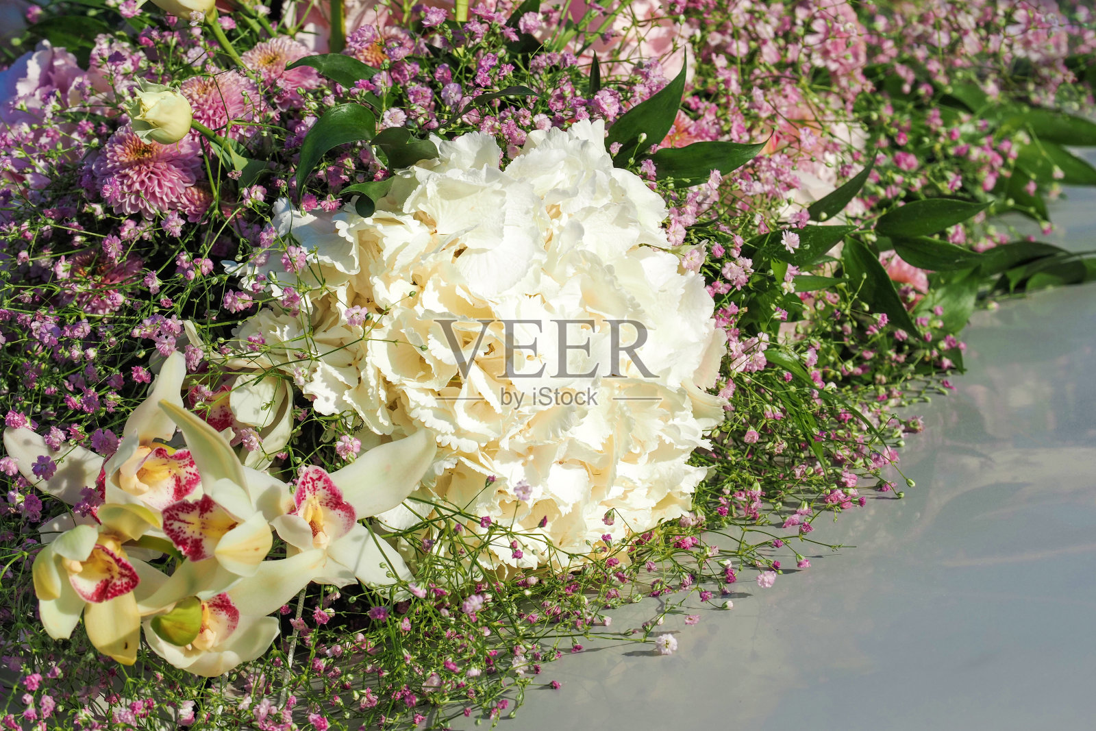 白色的绣球花和兰花，粉色的雏菊和槐花。精致的车顶装饰，色彩柔和照片摄影图片