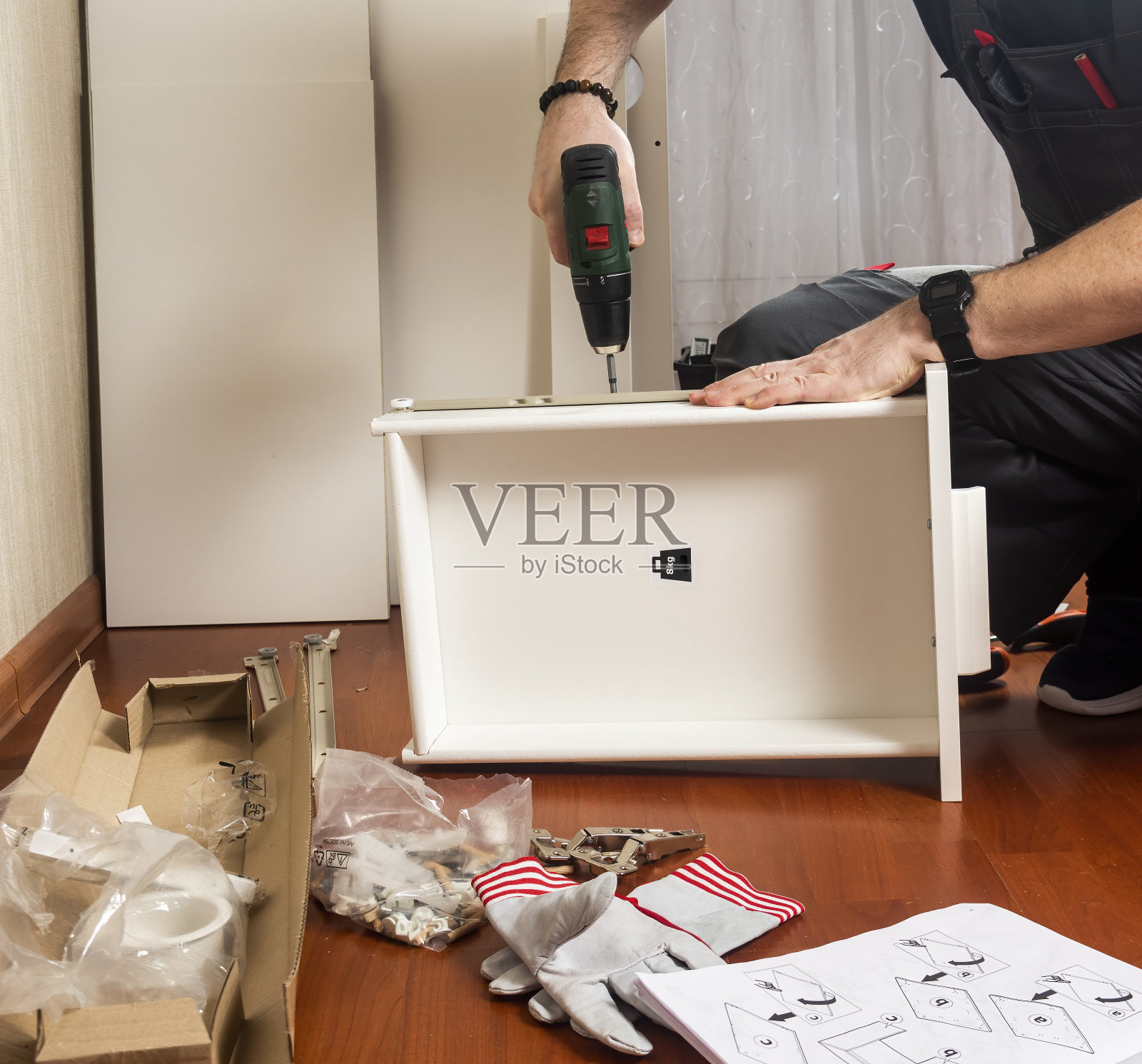 一个男人正在一间新公寓里组装家具照片摄影图片