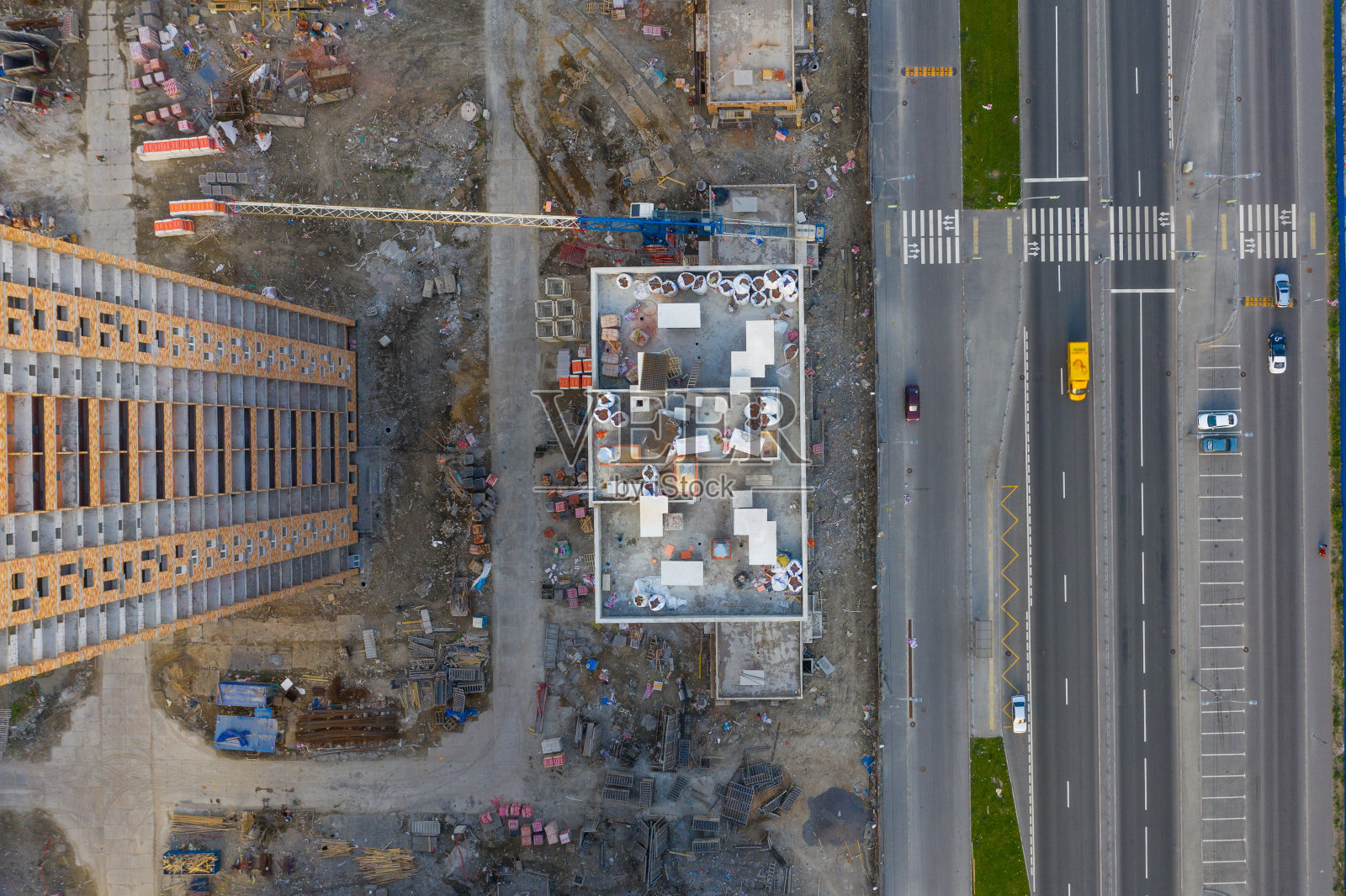 正在施工的高层住宅，街道上到处都是塔吊和建筑材料。从高空俯瞰。照片摄影图片