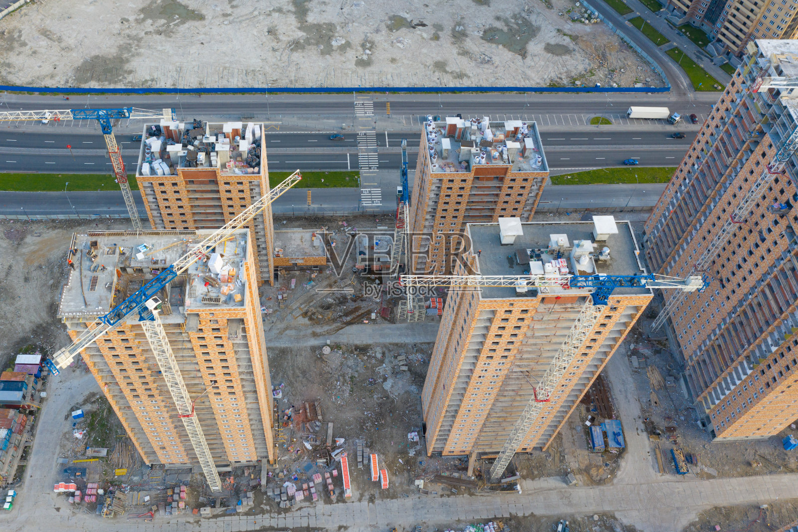 鸟瞰某大型建筑小区的顶视图，可以看到建筑起重机的蓝天。照片摄影图片