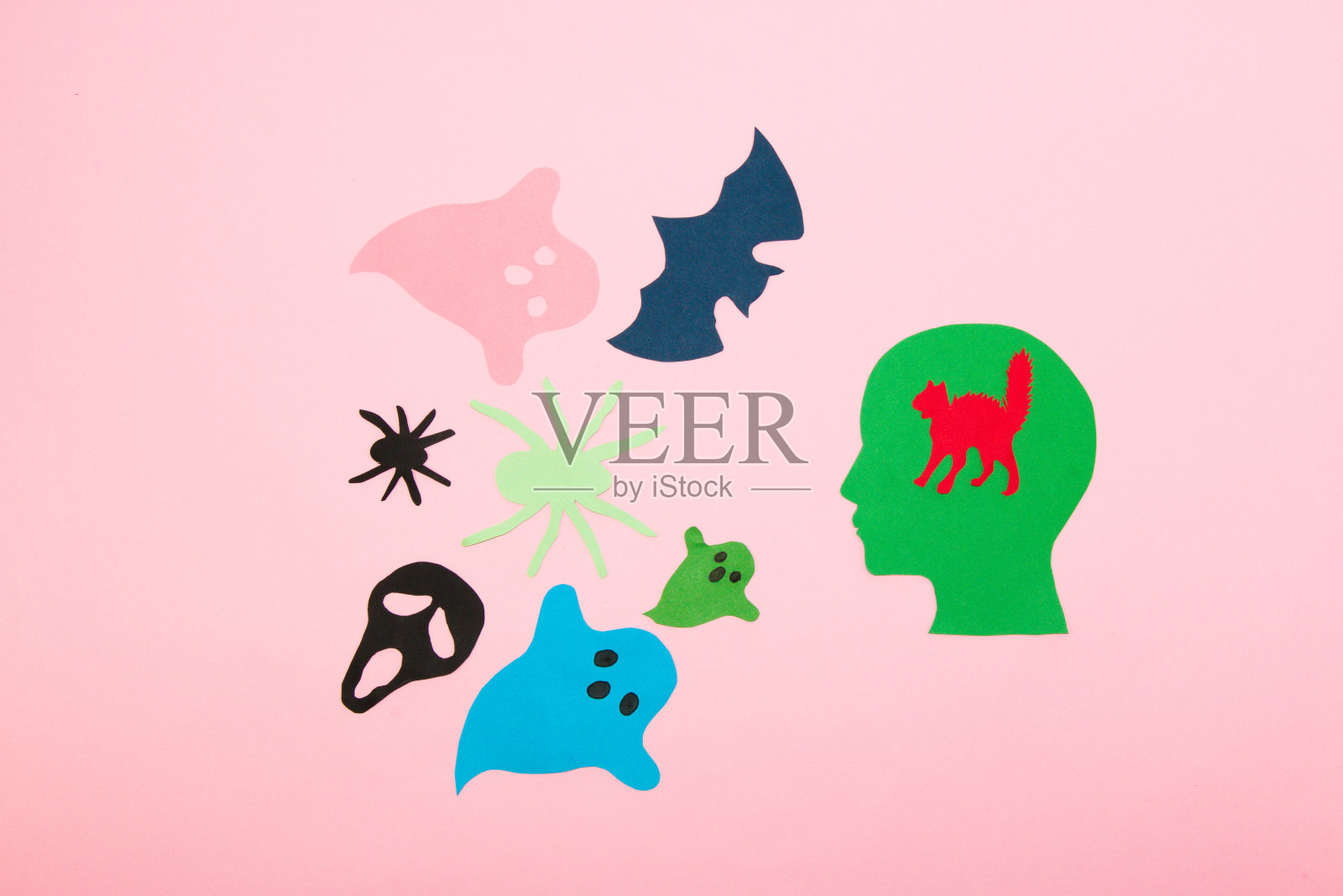 纸头上长着一只受惊的小猫的脑袋，被人吓得万圣节妖怪，平躺着，纸上工艺品，创意十足照片摄影图片