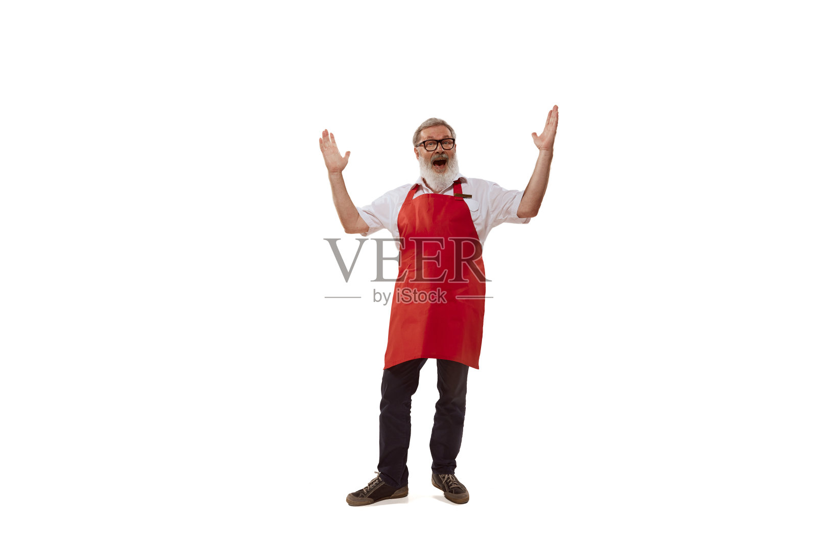 高级男子的肖像，兴高采烈的推销员在红色围裙摆姿势孤立的白色背景。欢迎客户照片摄影图片