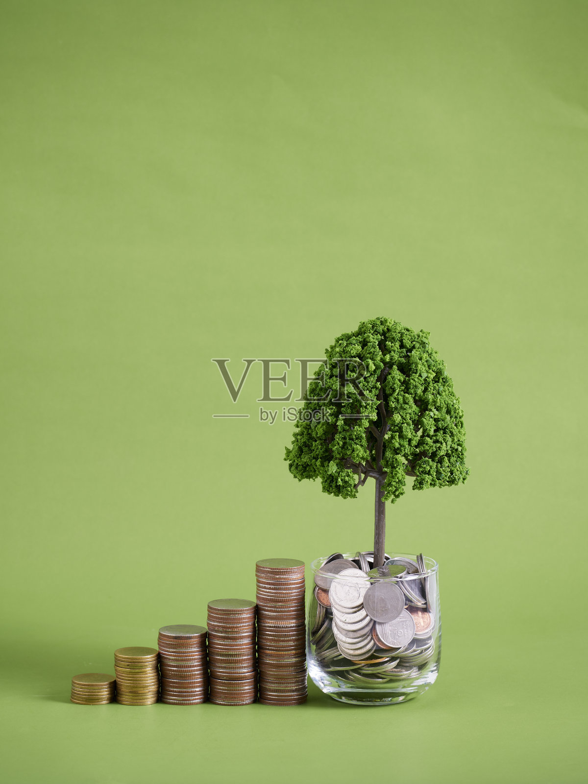 堆叠的硬币在绿色背景。金融概念照片摄影图片