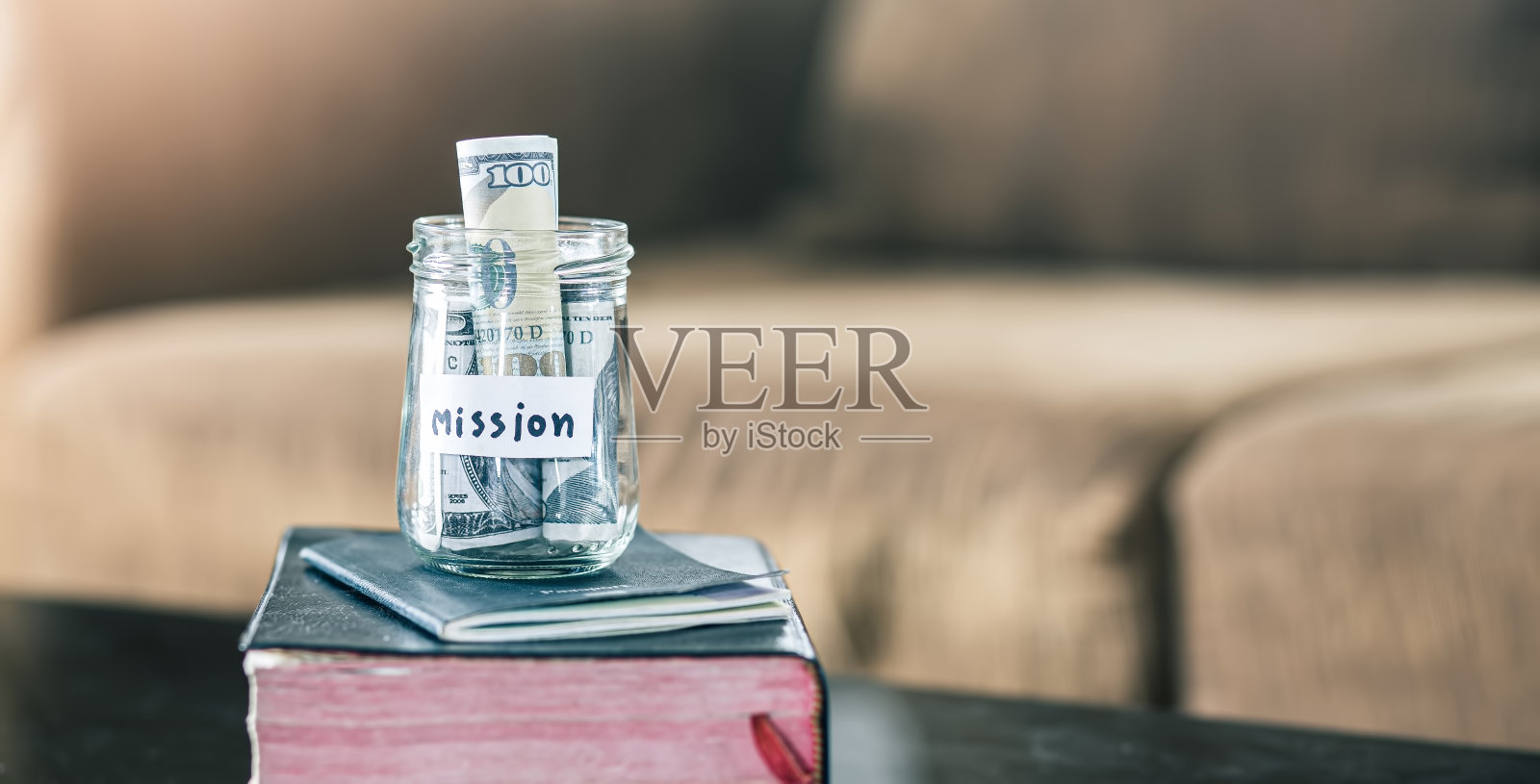 储蓄罐里装满了护照和基督教教义的圣经。照片摄影图片