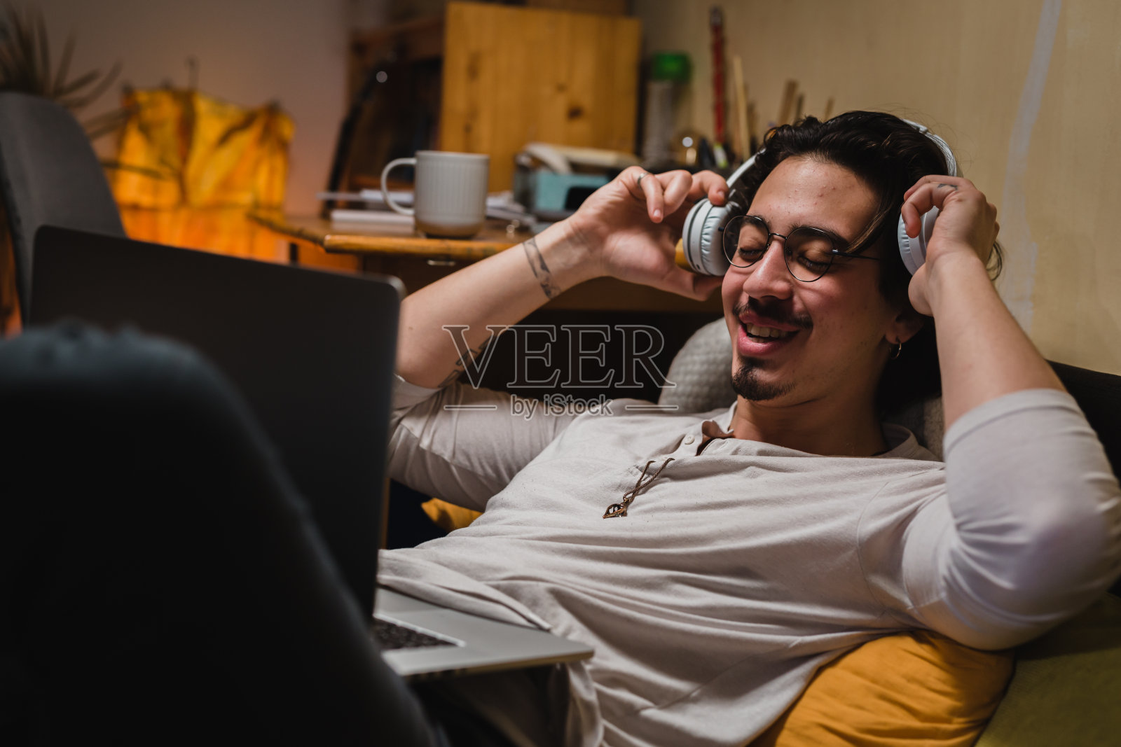 年轻的成年男子在他的房间里休息照片摄影图片