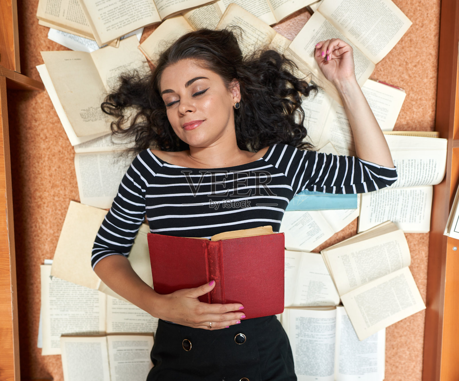 年轻的褐发女子在藏书丰富的图书馆里照片摄影图片