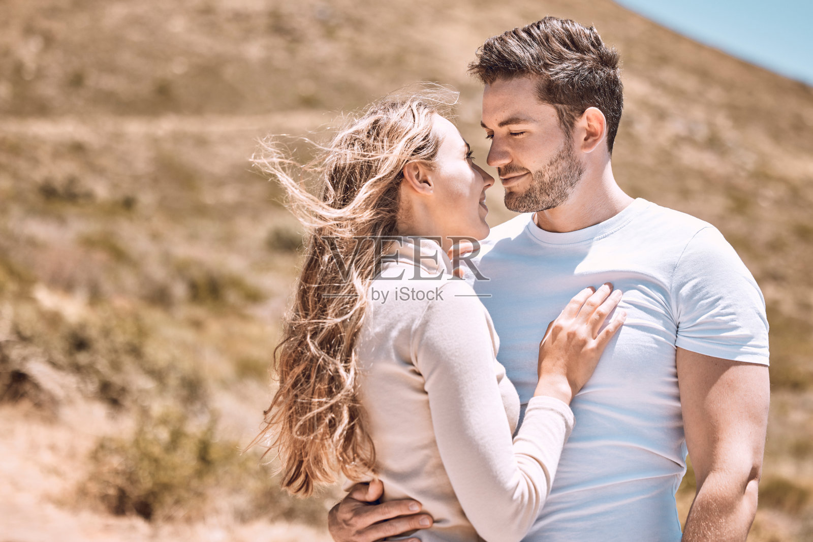 在爱中，拥抱和亲密的年轻夫妇快乐，在户外度假度假的微笑。在夏日的阳光下，浪漫的情侣一起在户外放松，拥抱并热爱浪漫、幸福和阳光照片摄影图片