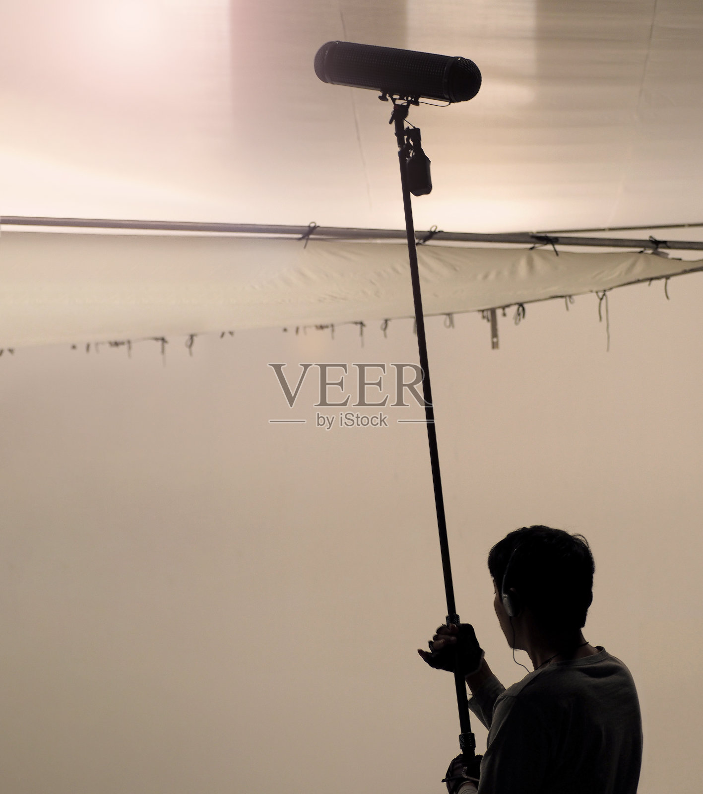 由麦克风fisher为电影在摄影棚录制声音的音幕操作员。照片摄影图片