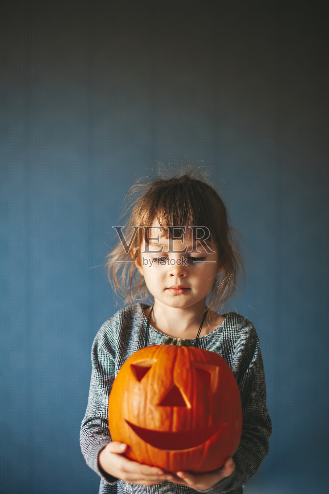 一个小女孩拿着万圣节南瓜的肖像照片摄影图片