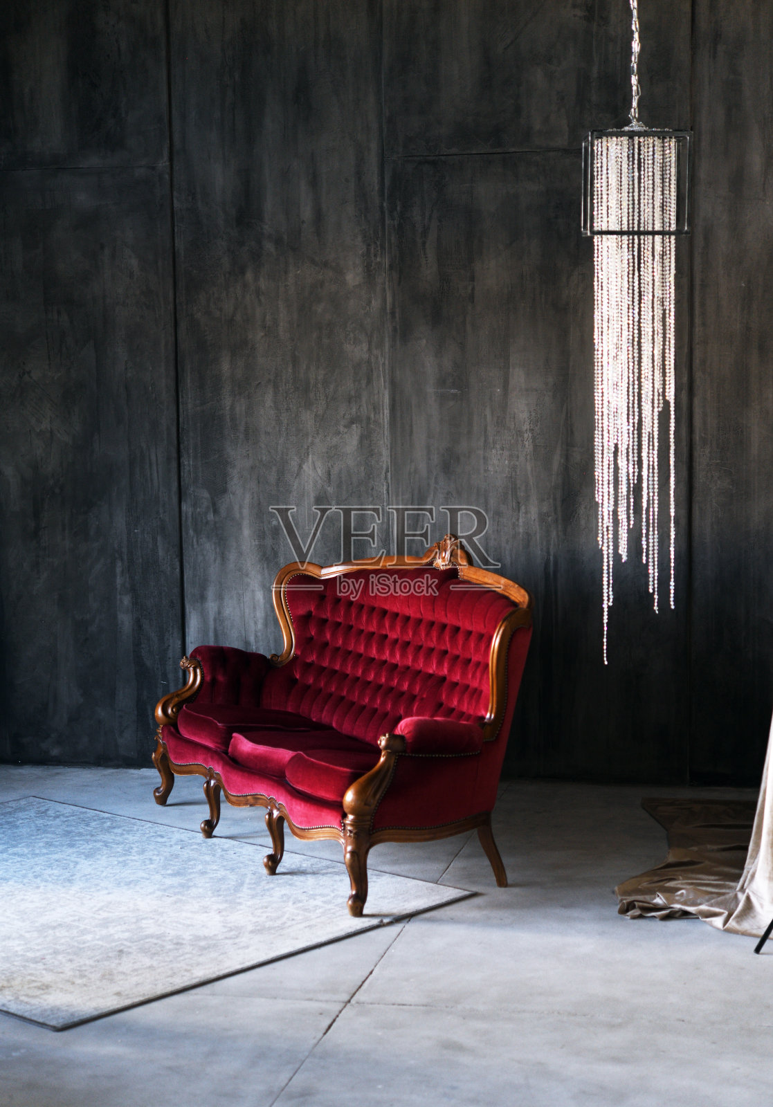 红色老式沙发，靠着灰色的墙。照片摄影图片